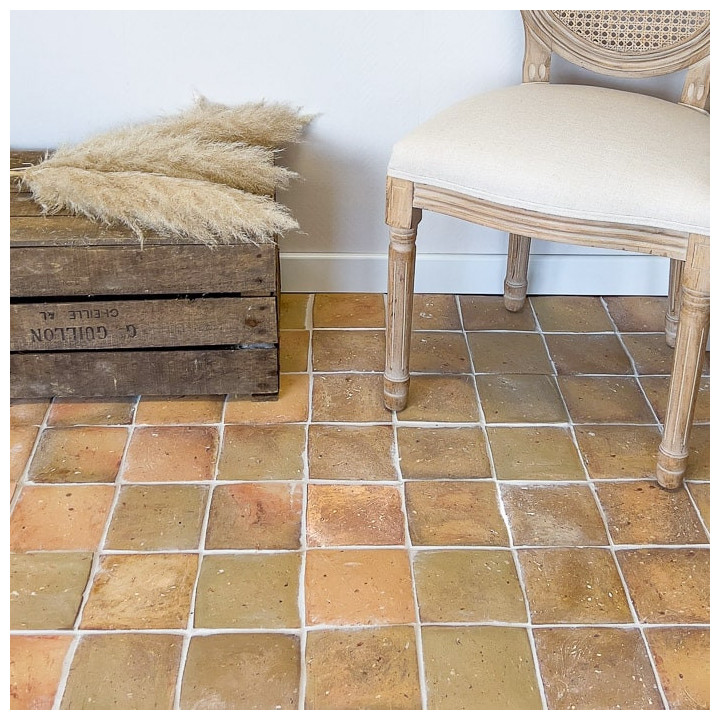 Tomette carrée claire posée avec chaise et cage en bois