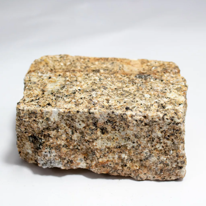 zoom sur un pavé en granit jaune sur fond blanc