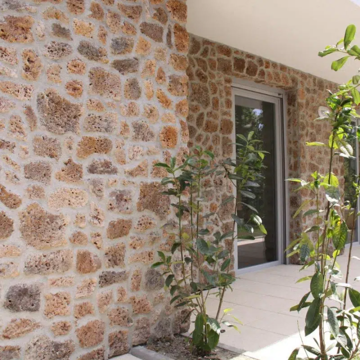 Façade d'une maison entièrement effectuée avec de la pierre de parement meulière