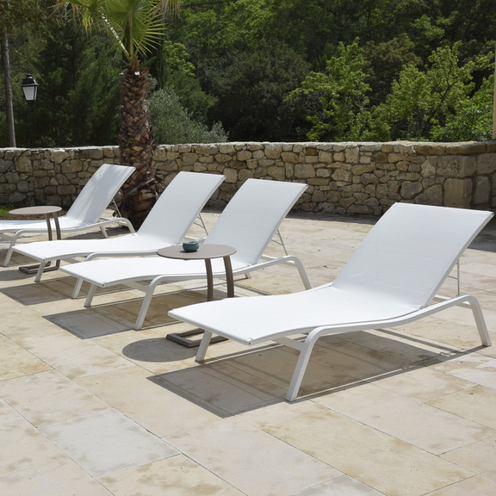 Dallage pierre naturelle beige Castel avec des chaises longues blanches dans un jardin moderne
