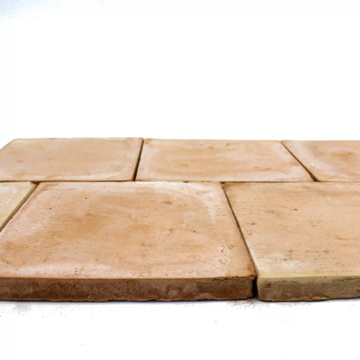 Zoom sur épaisseur d'une tomette terre cuite carrée moulée main rosée