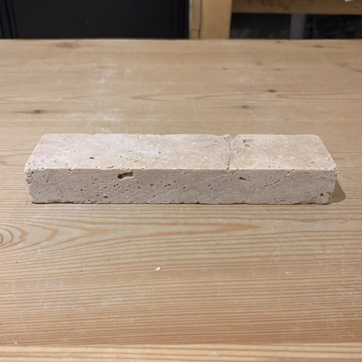 un pavé en travertin rectangulaire posé sur une table