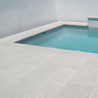 sol pierre calcaire claire autour d'une piscine