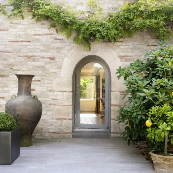 Entrée extérieur avec des pierres de parement, avec des plantes et un gros vase