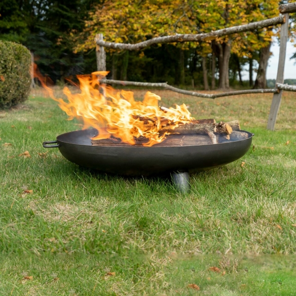 brasero trépieds bas enflammé dans un jardin