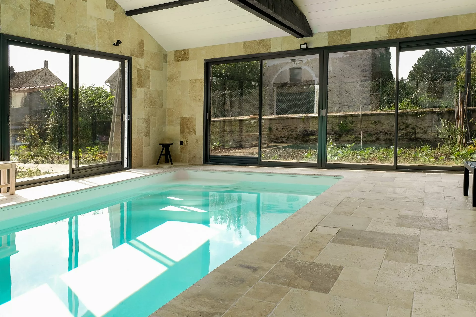 Piscine intérieure et travertin